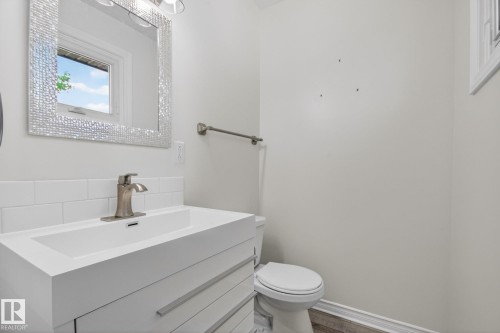 Modern vanity with integrated sink, brushed nickel faucet, and subway tile backsplash - 3 Galaxy Way, Sherwood Park, AB 