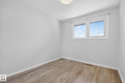 Bright interior space featuring a double window, wood-finish flooring, white baseboards, and a semi-flush ceiling light fixture - 3 Galaxy Way, Sherwood Park, AB 