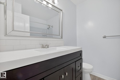 Bathroom featuring a dark wood-finish vanity with a white countertop and integrated sink - 3 Galaxy Way, Sherwood Park, AB 