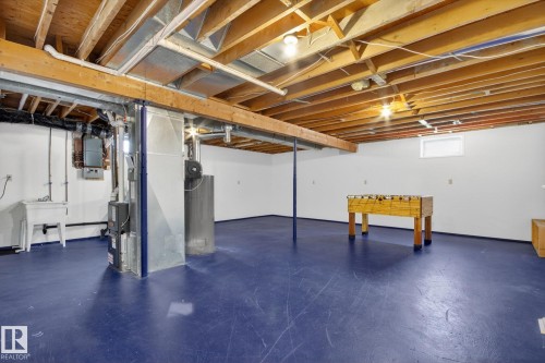 Lower level space featuring exposed ceiling joists, painted concrete flooring, and a utility sink - 3 Galaxy Way, Sherwood Park, AB 