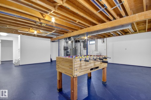 Spacious lower level featuring exposed wood joists, bright overhead lighting, painted concrete flooring, and substantial open areas - 3 Galaxy Way, Sherwood Park, AB 