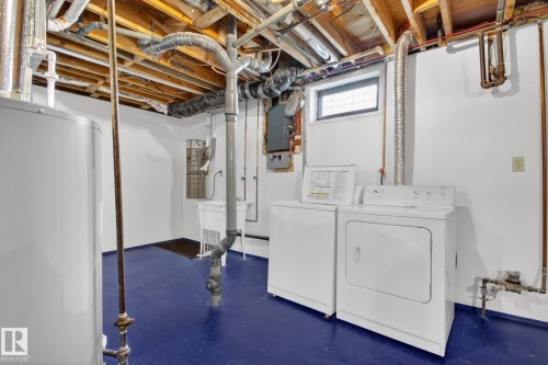 Laundry area featuring a utility sink, a small window, exposed ceiling joists, and a painted concrete floor - 3 Galaxy Way, Sherwood Park, AB 