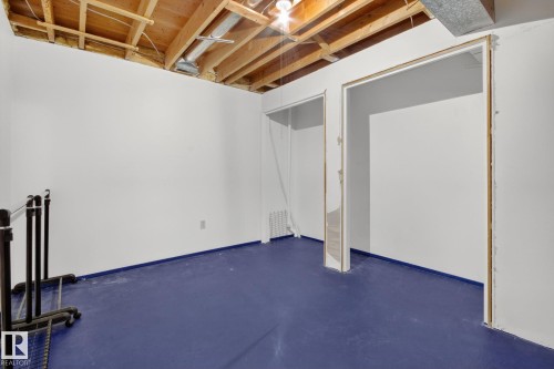 Room featuring exposed ceiling joists, white painted walls, and blue painted concrete flooring - 3 Galaxy Way, Sherwood Park, AB 