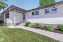 Front exterior featuring white horizontal siding, a dark grey roofline, multiple windows, and a concrete pathway leading to the entry - 3 Galaxy Way, Sherwood Park, AB 