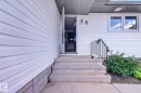 Exterior entry featuring concrete steps, wrought iron handrail, and white siding - 3 Galaxy Way, Sherwood Park, AB 
