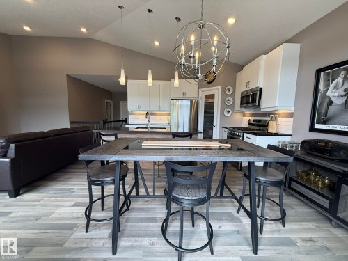 Open-concept living area featuring vaulted ceilings, wood-finish flooring, and recessed lighting - 2 104 Allard Link, Edmonton, AB 