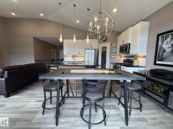 Open-concept living area featuring vaulted ceilings, wood-finish flooring, and recessed lighting - 