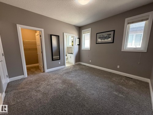 Carpeted room with neutral tone walls and white trim - 2 104 Allard Link, Edmonton, AB 