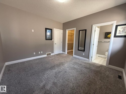 Carpeted room with neutral wall paint and white trim - 2 104 Allard Link, Edmonton, AB 