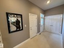 Entryway featuring light neutral wall paint, white trim, recessed lighting, and tile flooring - 2 104 Allard Link, Edmonton, AB 