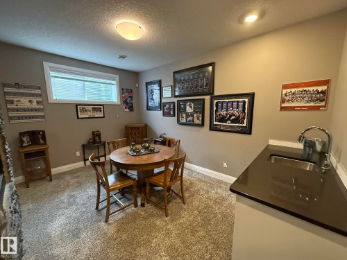 Integrated wet bar featuring a stainless steel sink and dark countertop - 2 104 Allard Link, Edmonton, AB 