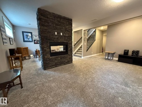 Central stone-clad fireplace with an integrated linear firebox - 2 104 Allard Link, Edmonton, AB 