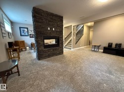 Central stone-clad fireplace with an integrated linear firebox - 