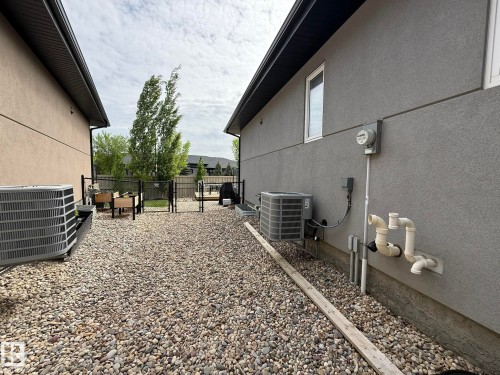 Side yard with gravel landscaping and chain-link fencing - 2 104 Allard Link, Edmonton, AB 