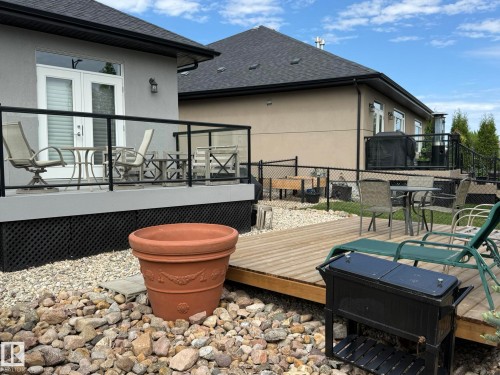 Elevated deck featuring glass panel railings and a white French door entry - 2 104 Allard Link, Edmonton, AB 