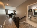 Open-concept living space featuring wood-finish flooring, recessed lighting, and a large window with horizontal blinds - 2 104 Allard Link, Edmonton, AB 
