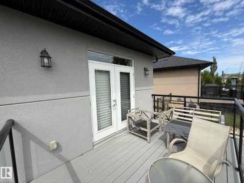Upper-level balcony featuring composite decking, white French doors, and black metal railings - 2 104 Allard Link, Edmonton, AB 