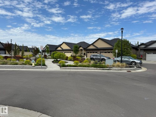 Cul-de-sac street with a central landscaped island featuring mature shrubs and trees - 2 104 Allard Link, Edmonton, AB 