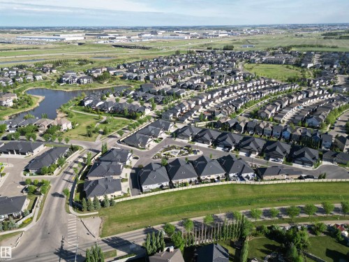 Aerial perspective showcasing a residential community with diverse single-family homes, organized street layouts, and extensive green spaces - 2 104 Allard Link, Edmonton, AB 