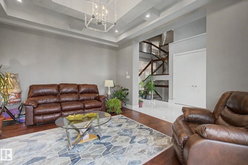 Living area featuring wood-finish flooring, recessed lighting, and a tray ceiling - 3036 59 Avenue, Rural Leduc County, AB 