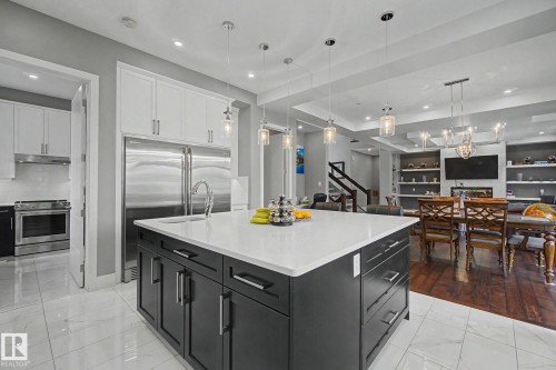 Kitchen island featuring a white countertop and dark cabinetry with brushed nickel hardware - 3036 59 Avenue, Rural Leduc County, AB 