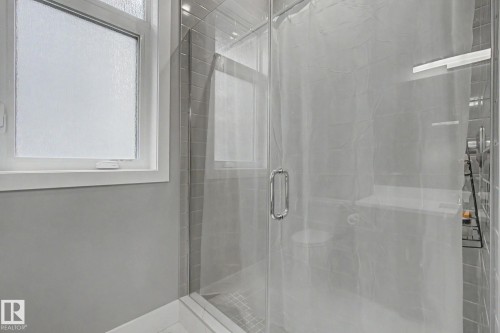 Glass-enclosed shower featuring subway tile surround and built-in shelving - 3036 59 Avenue, Rural Leduc County, AB 