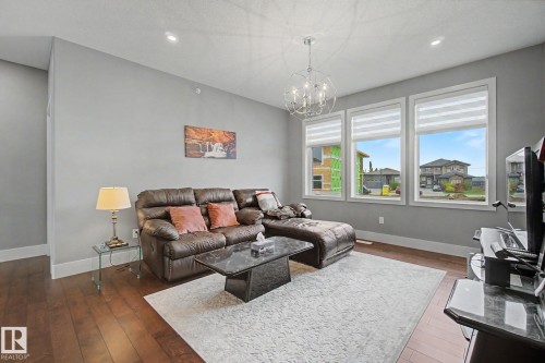 Living room with recessed lighting and a contemporary chandelier - 3036 59 Avenue, Rural Leduc County, AB 