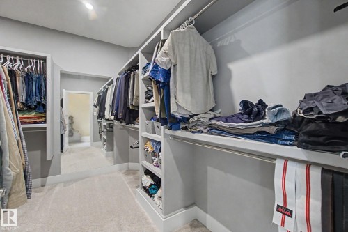 Spacious walk-in wardrobe featuring extensive built-in shelving, multiple hanging rods, and light gray cabinetry - 3036 59 Avenue, Rural Leduc County, AB 