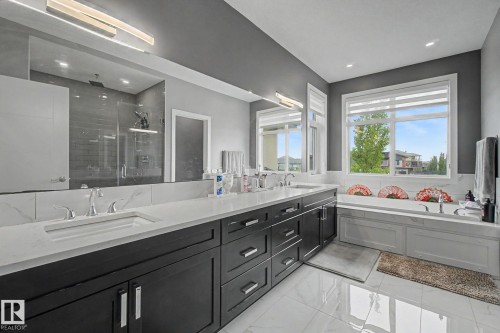 Dual vanity with integrated sinks, white countertops, and dark cabinetry - 3036 59 Avenue, Rural Leduc County, AB 