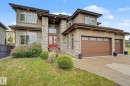 Contemporary exterior featuring stacked stone accents and neutral stucco finish - 3036 59 Avenue, Rural Leduc County, AB 