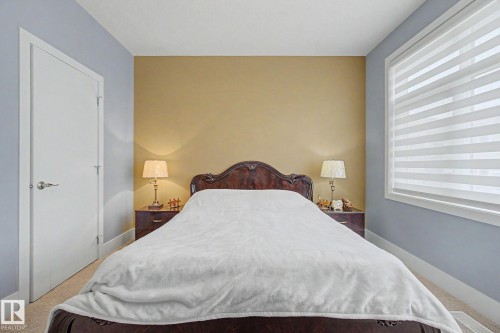 Bedroom featuring a neutral accent wall and contrasting cool-toned walls - 3036 59 Avenue, Rural Leduc County, AB 