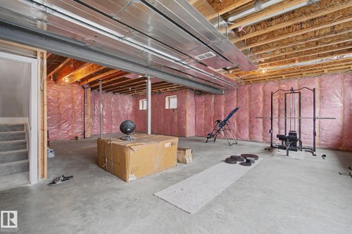 Unfinished basement space with concrete flooring, exposed ceiling joists, and visible insulation along perimeter walls - 3036 59 Avenue, Rural Leduc County, AB 
