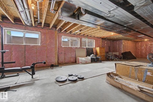 Unfinished basement featuring exposed wood joists, visible ductwork, concrete flooring, and multiple window openings - 3036 59 Avenue, Rural Leduc County, AB 