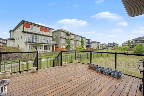 Expansive wood-finish deck with a black metal and glass railing - 3036 59 Avenue, Rural Leduc County, AB 