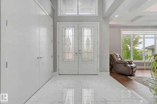 Double entry doors with decorative glass panels and a transom window - 3036 59 Avenue, Rural Leduc County, AB 