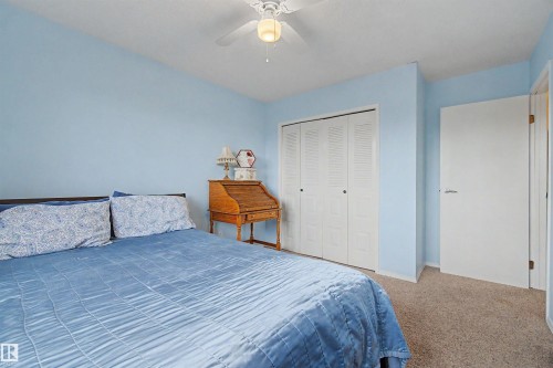Carpeted interior space featuring light blue walls, a white ceiling fan with integrated lighting, and white bi-fold closet doors - 2068 45 Street, Edmonton, AB - Indoor Photo Showing Bedroom