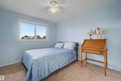 Bedroom featuring a large window, light blue walls, and carpet flooring - 2068 45 Street, Edmonton, AB - Indoor Photo Showing Bedroom