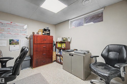 Bright and versatile bedroom space used as an office with light-colored carpeting, a drop ceiling featuring recessed lighting, and a horizontal window providing natural illumination - 2068 45 Street, Edmonton, AB - Indoor Photo Showing Office