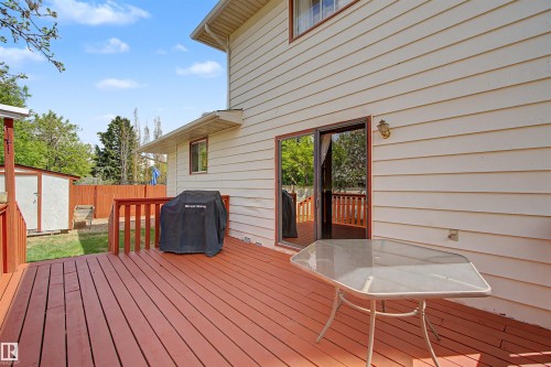 Spacious wood deck with red-stained railings and a sliding glass door entry to the interior - 2068 45 Street, Edmonton, AB - Outdoor With Deck Patio Veranda With Exterior