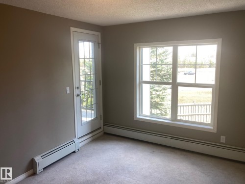 Neutral-toned interior with light tan walls and a textured ceiling - #206 616 Mcallister Lo Sw, Edmonton, AB - Indoor Photo Showing Other Room