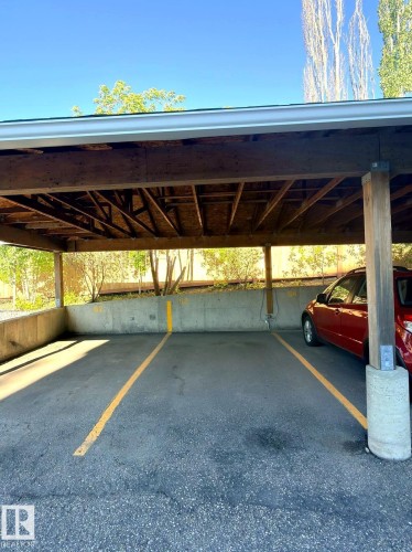 Covered parking space with asphalt surface and overhead wood beam construction - 312 2305 35A Avenue, Edmonton, AB 