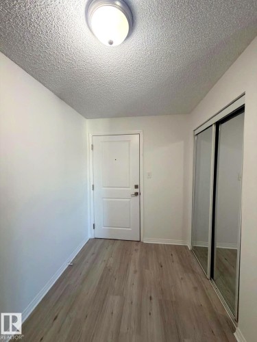 Entryway featuring light wood-finish flooring and a white paneled door - 312 2305 35A Avenue, Edmonton, AB 