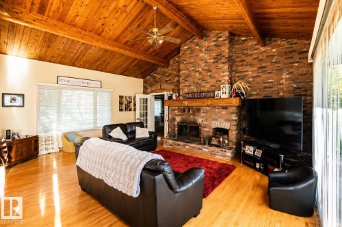 Vaulted wood-paneled ceiling with exposed beams - 58124 Secondary 881, Rural St. Paul County, AB - Indoor Photo Showing Living Room With Fireplace