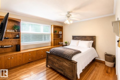 Hardwood flooring throughout featuring extensive built-in cabinetry and shelving with a window bench - 58124 Secondary 881, Rural St. Paul County, AB - Indoor Photo Showing Bedroom