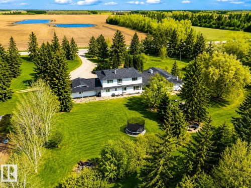 Expansive property featuring a white two-story residence with a dark shingle roof, surrounded by a verdant lawn - 58124 Secondary 881, Rural St. Paul County, AB - Outdoor With View