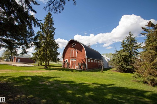 Red barn with gambrel roof, white trim accents, and multiple windows - 58124 Secondary 881, Rural St. Paul County, AB - Outdoor