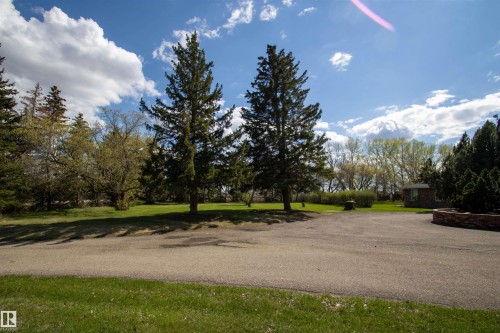 Spacious paved driveway with surrounding greenery and mature trees - 58124 Secondary 881, Rural St. Paul County, AB - Outdoor With View