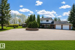 Expansive paved driveway leading to a two-story residence with a three-car garage - 