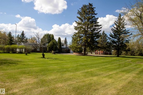 Expansive green lawn with mature evergreen trees and additional deciduous trees - 58124 Secondary 881, Rural St. Paul County, AB - Outdoor With View