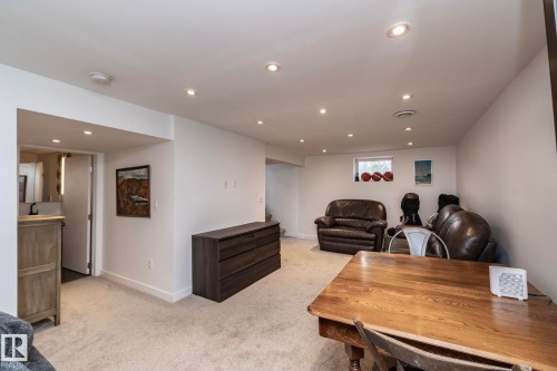 Recessed lighting illuminates this versatile space featuring light-toned carpeting and neutral wall finishes - 7719 86 Avenue, Edmonton, AB 